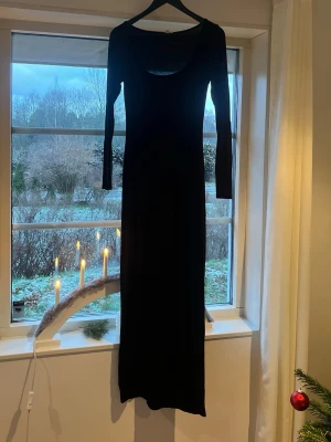 Svart långklänning från Nelly - Svart långklänning från Nelly i storlek S. Klänningen har en rundad, djup urringning och långa ärmar. Materialet är mjukt och stretchigt, vilket ger en slim passform. Enkel och stilren design som är lätt att matcha med accessoarer. Jättesnygg klänning som passar till flera olika tillfällen 😍nästan ny, använd endast en gång 