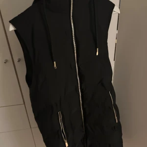 Zara svart väst - Fin lång väst från Zara med guld detaljer 