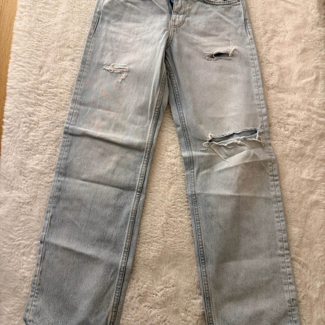 Ljusblå raka jeans med slitningar