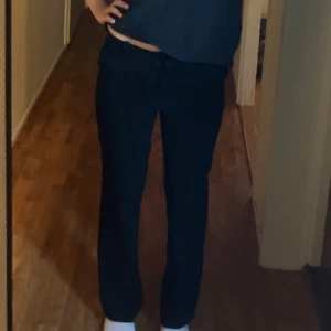 Svarta kostymbyxor från Vero Moda - Svarta kostymbyxor från Vero Moda med rak passform och klassisk look. Byxorna har dragkedja och knapp framtill samt hällor för bälte. Perfekta för en clean och stilren outfit.