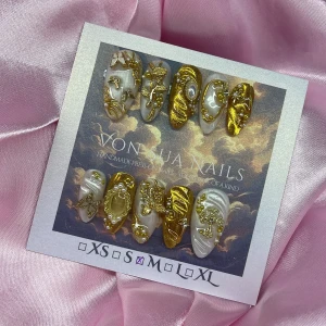 EternalGold (M);Medium Almond - Handgjorda press-on naglar i en medium mandelform med skimrande pärlemorvit och metallic guld. Dekorerade med 3D-detaljer, pärlor och guldfärgade ornament. Snyggt barock-inspirerat mönster som verkligen sticker ut. Perfekt för dig som vill ha unika och glamorösa naglar. I storlek M: 16 mm, 12 mm, 12,5 mm, 11,5 mm, 10 mm