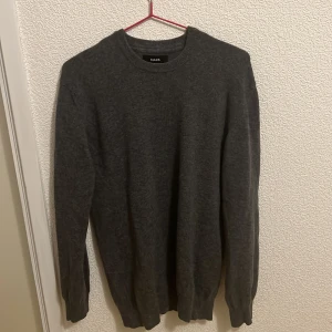Mörkgrå stickad tröja Mads Nørgaard - Mörkgrå stickad tröja från Mads Nørgaard med rund halsringning och långa ärmar. Enkel och stilren design som passar perfekt till lager-på-lager. Mjuk och skön känsla, perfekt för kyligare dagar. Pris kan diskuteras