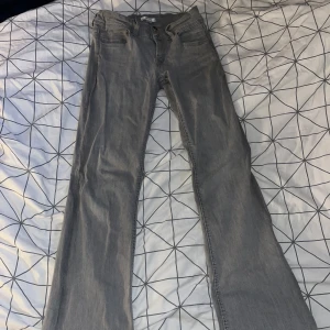 Grå jeans från Gina Tricot, storlek 158 - Snygga grå jeans från Gina Tricot i storlek 158. Klassisk femficksmodell, bootcut jeans och normal passform. Jeansen har dragkedja och knapp framtill och är tillverkade i mjukt bomullsmaterial med lite stretch för extra komfort.