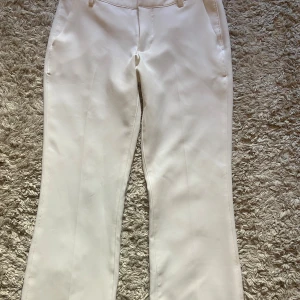 Vita bootcut kostymbyxor från Bik Bok - Snygga vita kostymbyxor från Bik Bok i storlek 34. Byxorna har raka ben med slits nertill. Även lågmidjade. Knappt använda då de är för korta 🤗
