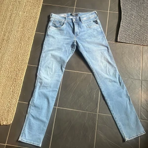 Replay Anbass Hyperflex ljusblå jeans - Säljer ett par Replay Hyperflex jeans i ljusblå tvätt. Modellen har skinny passform, klassiska fem fickor och snygga detaljer på bakfickorna. Jeansen är tillverkade i stretchigt denim för extra komfort och rörelsefrihet.