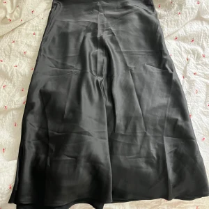 Svart satinkjol från Monki - Helt oanvänd. Passar som en 40