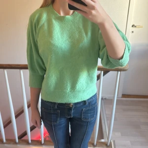 Grön stickad tröja med trekvartsärm - Mysig grön stickad tröja med rund halsringning och trekvartsärmar. 