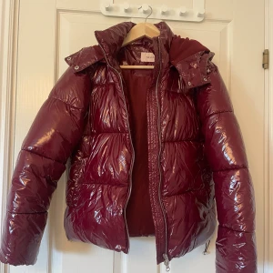 Pufferjacka - Vinröd pufferjacka ”Everyday shiny puffer jacket” från Nelly. Använd vid fåtal tillfällen så mycket fint skick. Nypris 799kr