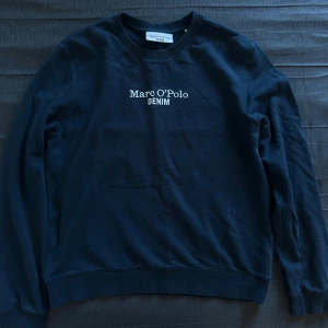 Marc O’Polo Denim sweatshirt – mörkblå, strl L (mer som M/S) - Sweatshirt från Marc O’Polo Denim i mörkblå nyans. Storlek L i lappen, men passar bättre som M eller liten S. Bekväm och stilren med broderad logga framtill. Säljes eftersom den blivit för liten.