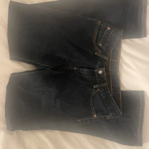 Levi's 545 mörkblå jeans W28 L32 - Mörkblå Levi's 545 jeans med låg midja och klassiska kontrastsömmar och femficksdesign. Jeansen har rak/bootcut passform och är tillverkade i slitstarkt denimtyg. Perfekta för dig som gillar en tidlös look med snygga detaljer och ikonisk Levi's-lapp bak i midjan.