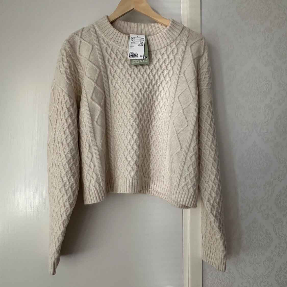 Beige stickad tröja med flätmönster