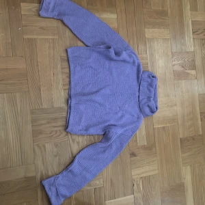 Lila polotröja från Lindex, stickad - Supermysig lila stickad polotröja från Lindex. Tröjan har lång ärm, ribbade muddar och en hög polokrage som ger extra cozy vibes. Perfekt för kyliga dagar och enkel att styla med jeans eller kjol.