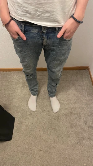 Tiger of Sweden jeans med slitningar  - Tja! Jag säljer ett par sköna Tiger of Sweden jeans med små slitningar. Jeansen är i bra skick,storleken 30/32. Modellen på bilden är 185. Hör av dig vid intresse eller om du vill ha några fler bilder! 🙌