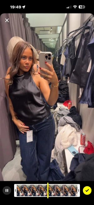 Svart satin linnetopp  - Supersnygg svart linnetopp i satin med halterneck och ärmlös design. Toppen har en slät, glansig yta och sitter snyggt mot kroppen. Perfekt för dig som gillar stilrena och trendiga plagg med lite lyxig känsla. ( super trendig ) kommer inte  till användning. har aldrig använt den. Nypris 350