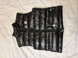 Moncler gui väst  - Har haft det liggande länge men har inte använt på grund att att det inte passar och nu vill jag blir av med västen, det är defekter vid triangeln vid dragkedjan men det kommer med från förra ägaren men annars allt fungerar som det ska,hör av er om ni är intresserad