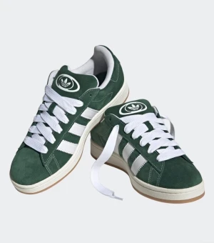 Adidas Campus gröna sneakers mocka - Adidas Campus sneakers i mörkgrön mocka med klassiska vita ränder på sidorna och vit Adidas-logga på plösen och hälen. Skorna har rund tå, platt sula och vita snören. Snygg retrostil med låg profil och gummisula som ger bra grepp.