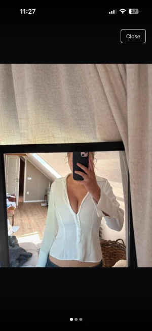 Vit figursydd skjorta från Zara - Säljer en vit, figursydd skjorta från Zara med djup v-ringning och långa ärmar. Skjortan har klassisk krage och knappar framtill, vilket ger en clean och stilren look. Perfekt för dig som gillar en feminin och modern stil. 💅