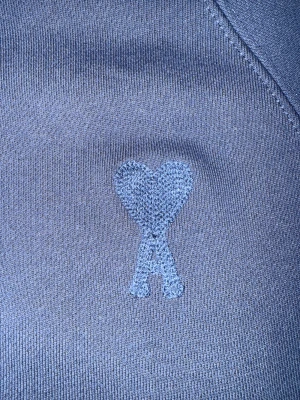 Blå Ami Paris hoodie med hjärta - Snygg marinblå hoodie från Ami Paris med det klassiska broderade hjärta-A på bröstet. Perfekt för dig som gillar stilrena streetwear-plagg med exklusiv känsla.