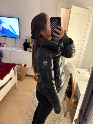 Glansig Colmar jacka - Säljer en svart pufferjacka från Colmar som är glansig. Fint skick förutom en liiiitet hål som har en lagning över, bild ( s.4 ), men det syns inte när man använder den. Nypris ligger runt 5 000. Pris kan diskuteras 