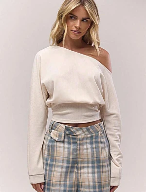 Beige offshoulder croppad topp - Säljer en beige croppad topp med offshoulder-design och långa ärmar. Toppen har en lätt ribbad struktur och sitter snyggt i midjan. Perfekt för dig som gillar en stilren och trendig look. Från Musera i nyskick och bra kvalitet