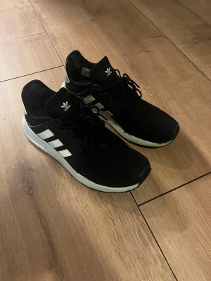 Adidas skor - Svart adidas skor, sköna , litet hål i sidan om man drar i skon men syns inte annars (se bild)