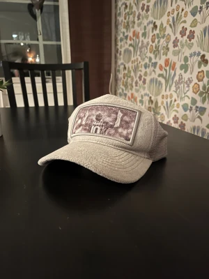 Grå grisch keps - Tjena! Säljer denna snygga grå keps med mjuk frottéliknande front och mesh på sidorna och bak. På framsidan finns ett stort tryck av Messi med nummer 10, armarna i luften. Perfekt för dig som älskar fotboll och vill ha en unik accessoar. Jag köpte den för 500 så jag släpper den för 300 i utgångspris då det använt bara några fåtal gånger.