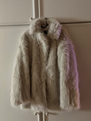 Vit pälsjacka - Säljer en oanvänd ny pälsjacka/vinterkappa med prislappen kvar från Lager157 i ”dusty white”  Stl L/XL Säljs inte längre  Ord pris 600kr 