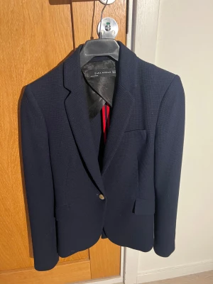 Jättefin marinblå kavaj från Zara, stl XS - Jättefin marinblå kavaj från Zara, stl XS, med guldknappar i midja och ärmslut, superfint begagnat skick, knappt använd!