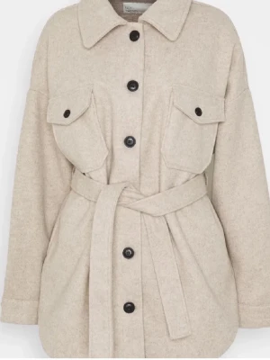 Beige jacka från NLY Trend - Säljer en beige overshirt från NLY Trend i storlek 34. Jackan har stora bröstfickor med knappar, bälte i midjan och svarta knappar framtill. Materialet är mjukt och känns ulligt, perfekt för lager-på-lager. Använd många gånger men i bra skick.