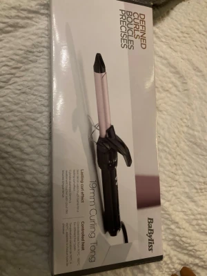BaByliss 19mm locktång - INTE ÖPPNAD ELLER ANVÄND!!! Säljer en BaByliss locktång med 19mm tunn stav i silver och svart. Perfekt för att skapa definierade lockar. Tången har ett ergonomiskt handtag och sladd med roterande fäste. Kommer i originalkartong.