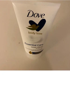 Dove Essential Care Hand Cream - Dove Essential Care Hand Cream med ceramide restoring serum, 48h återfuktning för torr hud. Tuben är vit med blå och guld detaljer, innehåller  100 ml. Dermatologiskt testad och PETA-godkänd. Perfekt för mjuka och återfuktade händer. Ej använd 