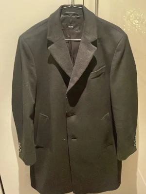 Hugo Boss cashmere-wool rock - Säljer min stilrena Hugo Boss rock i strl De 48 (M), använd fåtal gånger men har en liten skräddarsydd lagning vid ena fickan (syns inte vid användning). Köptes för ungefär 8 år sedan för runt 6000kr 