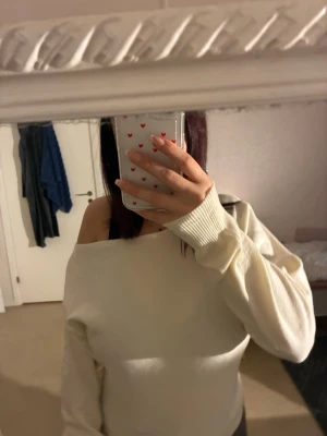 Offshoulder vit tröja från H&M - Säljer en  offshoulder tröja från H&M i storlek XS. Tröjan är vit, har lång ärm och är gjord i mjukt stickat material.