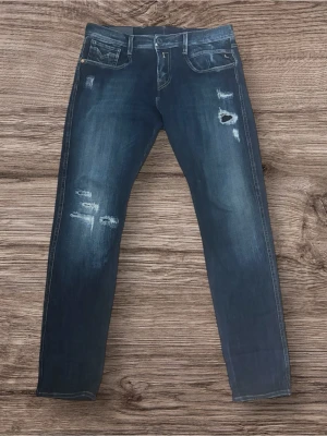 Replay Anbass Hyperflex - Säljer ett par replay anbass hyperflex som är riktig snygga och sköna. Den har riktiga feta slitningar och är stretchiga.   Dessa är i storlek 30/30.  Mått: Längd - 96cm, midja - 40cm, benöppning - 16cm.   Skriv vid minsta lilla fundering 🤩