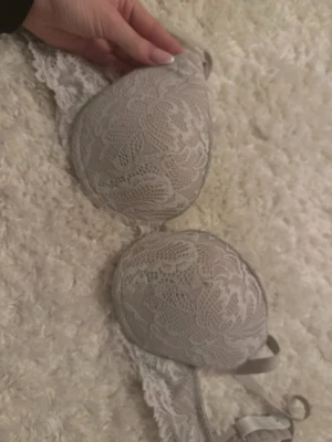 Beige spets-bh från Kappahl 75A - Säljer en beige bh från Kappahl i storlek 75A. Bh:n har vacker spets över hela kuporna och bandet, med tunna axelband och mjuk vaddering. Perfekt för dig som gillar en feminin och stilren look. Billigare pris vid köp av fler bh:ar!