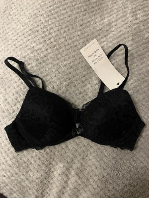 Svart push up bh - Säljer denna snygga svarta push up bh:n i spets från Hunkemöller. Den är helt ny och oanvänd, nypris 349kr, säljer pga att det blev fel storlek. 70A