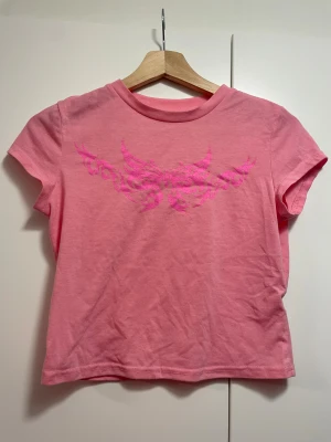 rosa baby tee - croppad, rosa tröja med korta ärmar och mörkrosa y2k detalj över bysten! lite nopprig, okänt märke