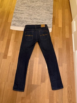  Nudie Lean Dean 30x32 - Nudie jeans i storlek 30x32 i modellen lean dean. Riktigt feta jeans i dry denim, så iommer få riktigt snygga fades med tiden. Även markerade med första användningsdatum på insidan så man vet hur länge dom har varat. Kvitto finns vid behov, skriv vid minsta fundering!