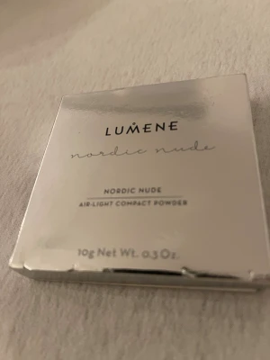Lumene Nordic Nude kompaktpuder - Lumene Nordic Nude Air-Light Compact Powder i färgen Nordic Nude. Kompaktpuder med lätt formula som ger en naturlig finish. Förpackningen är stilren och silvrig, innehåller 10g. Perfekt för att matta ner huden och jämna ut hudtonen.