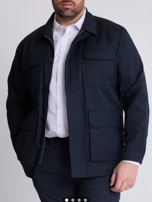 Navy Jacka  - Snygg Navy Jacka från Dressmann med klassisk krage och fyra stora fickor framtill. Jackan har både dragkedja och knappar, vilket ger en cool look. Tillverkad i bomull och polyester, perfekt för lager-på-lager. Passar dig som gillar stilrena och praktiska plagg.   Har bara testats men ej använd ute då det inte passade riktigt min stil.                        Nypris: 1500 