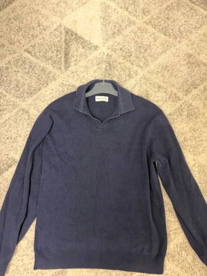 Marinblå pikétröja These Glory Days - Snygg marinblå pikétröja från These Glory Days i storlek medium. Tröjan har klassisk krage och är långärmad, perfekt för dig som gillar stilrena och enkla plagg. Materialet är mjukt och känns skönt mot huden.