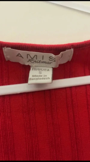 Röd ribbad omlottopp från Amisu - Säljer en snygg röd långärmad topp från Amisu i storlek S. Toppen har ribbad struktur och en omlottdetalj med twist framtill som ger en cool v-ringad look. Perfekt att styla med jeans eller kjol för en trendig vibe.