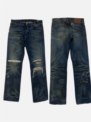 Denim & Supply Archive Sample Jeans 1 of 1  - Säljer ett par blå jeans från Denim & Supply med straight fit. Jeansen har slitna detaljer och revor på benen för en cool, avslappnad look. Klassisk femficksmodell med knappgylf och grova sömmar. Perfekt för dig som gillar streetstyle. Från sample sale, existerar endast dessa i Europa!! 32/32. Sjuka fades , distressing. Helt nya. 