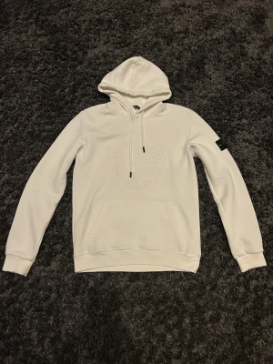 Vit Stone Island Hoodie - Riktigt snygg Stone Island hoodie i vit. Hoodien är i väldigt bra skick och den är i storlek S men. Otroligt skön och schysst nu när det är kyligt ute! Hör gärna av dig vid intresse och priset går alltid att diskutera!