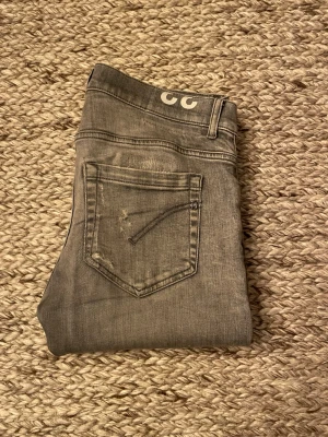 Grå Dondup George jeans - Säljer ett par grå Dondup George som inte kommer till användning längre. De är väldigt stretchiga vilket är skönt. Bra skick, har lagats i skrevet men det är inget som syns vid användning. Storlek 33, skulle säga att de sitter som 30/32 i vanliga jeans storlekar. //David