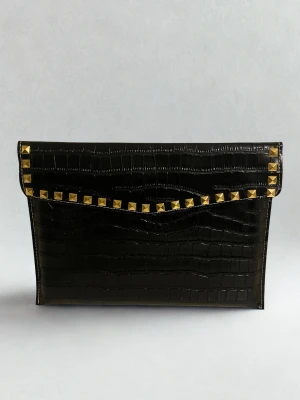 Datorfodral med guld nitar i krokodil imitation  -  Rea – endast 199 kr (ord. pris 249 kr)! Stilrent datorfodral tillverkat av veganskt läder i vattentätt material. Fodralet skyddar din dator effektivt samtidigt som det ger din outfit en extra touch. 😇⚜️ Storlek: 34 × 25 cm – passar svarta HP Chromebooks och andra datorer i liknande storlek. 