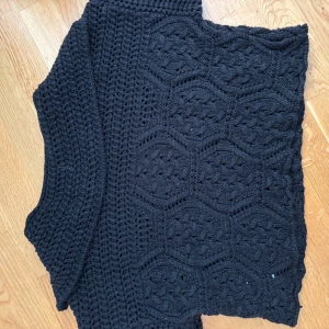 Svart stickad kofta från Zara - Säljer en svart stickad kofta från Zara i storlek S. Koftan har ett snyggt kabelstickat mönster V-formad framtill. Perfect everyday tröj! Materialet är mjukt och ger en mysig känsla.