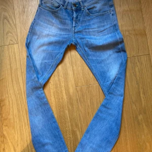 Blå Dondup skinny jeans, stl 31 - Säljer ett par ljusblå skinny jeans från Dondup, tillverkade i Italien. Jeansen har klassisk femficksdesign, knappgylf och snygga slitningar framtill. Perfekt passform med smala ben och cool tvätt. Materialet är mjukt och stretchigt jeans.