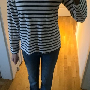 Randig långärmad tröja från 157 - Säljer en klassisk långärmad tröja från 157 med svartvita horisontella ränder. Tröjan är i mjuk bomull och har en avslappnad passform. Perfekt till jeans eller kjol för en chill look. Längd 55cm bred 46cm