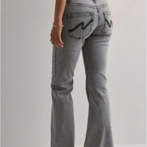 Grå bootcut jeans  - Snygga grå jeans med bootcut passform från Nelly. Dom har svarta detaljer på fickorna. Storlek 34💕 nypris 699kr💕pris kan diskuteras